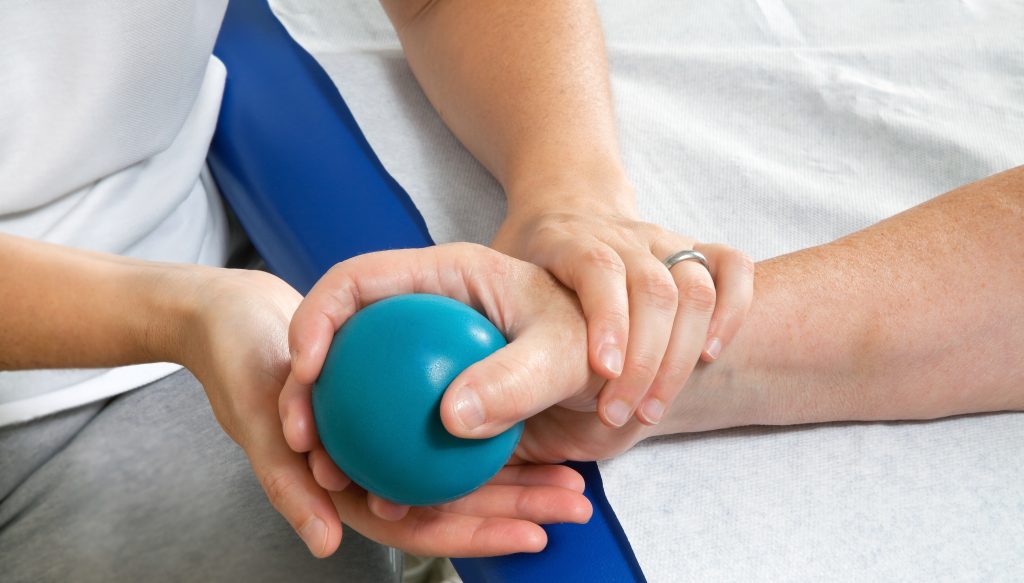 The hands of an Occupational Therapist assisting a patient with exercises. Inpatient Rehabilitation Facility