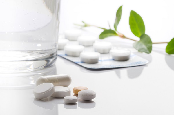 A picture of a glass of water and prescription medications