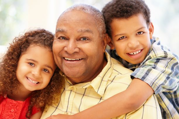 African American older adult man playing with his grandchildren. Exercise for senior citizens.