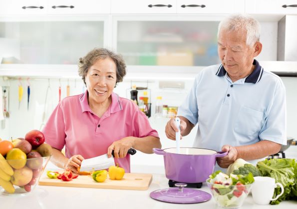 Older Asian man and woman preparing a meal at home. Exercise for seniors at home. 