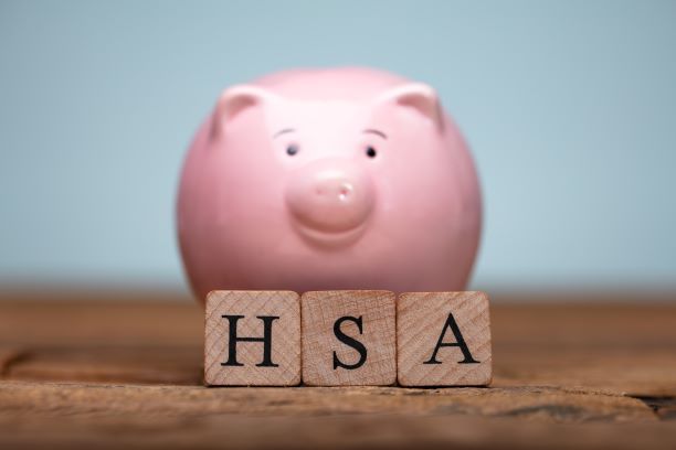 A small pink piggy bank with the blocks reading HSA in front. Health Insurance Alternatives for self-employed. Used as a descriptor for Health Savings Account.